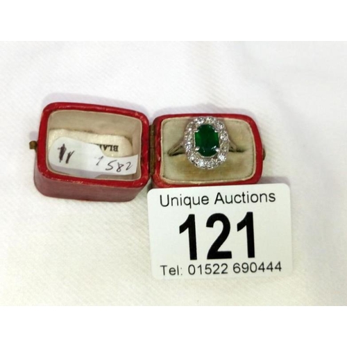 121 - An 18ct oval diamond and emerald ring