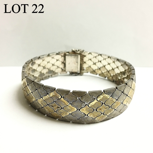 22 - A silver bracelet with gold inlay in a diamond shape formation, approximately 44.9g