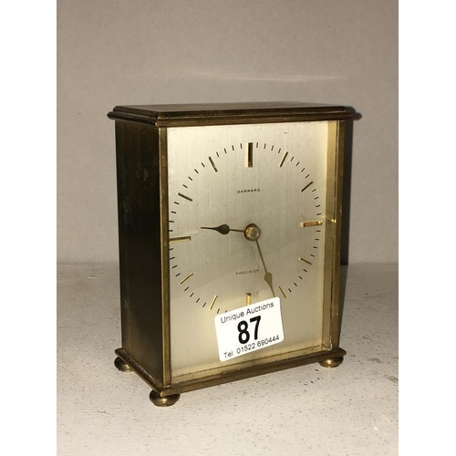 87 - A heavy Swiss brass clock by Garrard (in working order)