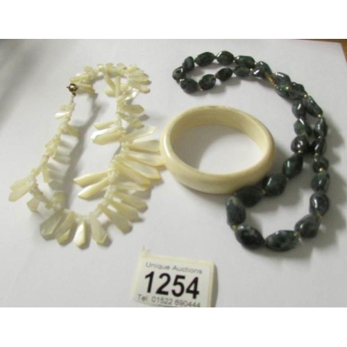 1254 - A mother of pearl necklace, an agate necklace and a bangle