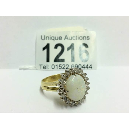 1216 - An 18ct white gold oval opal and diamond ring, size U