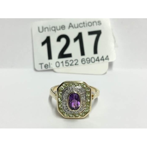 1217 - A yellow gold ring set with stones of suffragette colours, size T