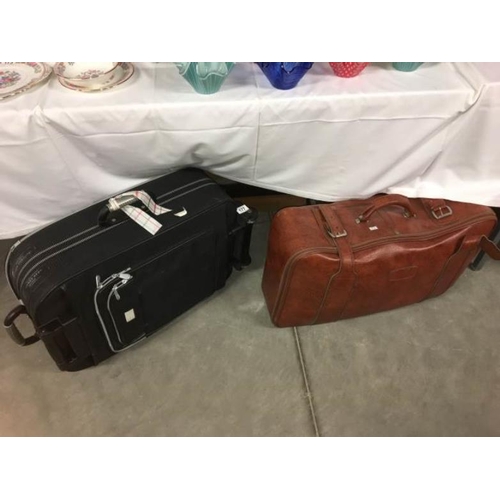 177 - A large leather suitcase and a travel suitcase on wheels