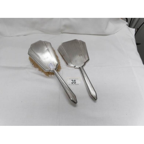 36 - A silver backed hand mirror and hair brush