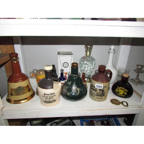 1059 - A mixed lot of assorted alcohol bottles, decanters etc including novelty (one shelf)