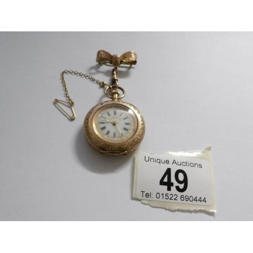 49 - An early 19th century 14ct gold ladies fob watch in chased gold with enamel face and surmounted by r... 