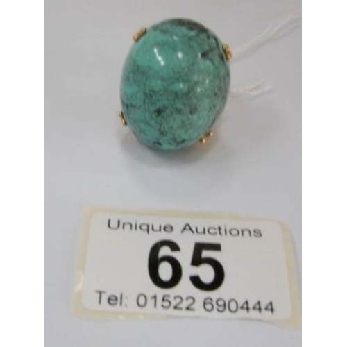 65 - A large 18ct gold turquoise set ring of ovate form in chased gold mount, circa 1970, (total weight 2... 