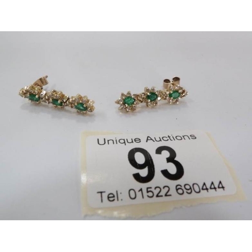 93 - A pair of 18ct gold emerald and diamond drop earrings