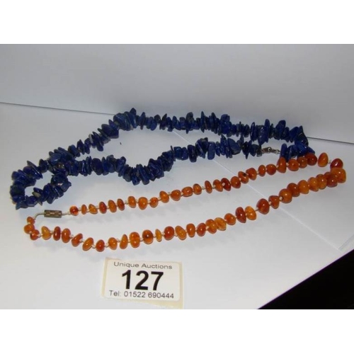 127 - An early natural amber necklace and a malachite necklace