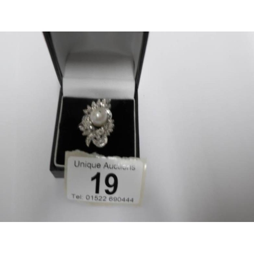 19 - A high carat white gold floral diamond ring with central pearl, size J