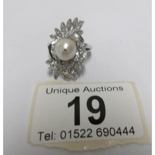 19 - A high carat white gold floral diamond ring with central pearl, size J