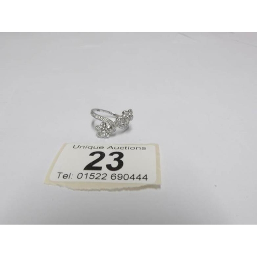 23 - An 18ct white gold 65pt diamond crossover ring, size M