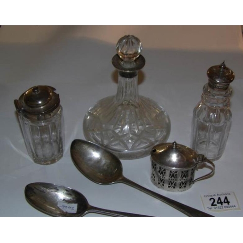 244 - A silver rimmed miniature ship's decanter, 2 silver topped bottles, a silver salt and 2 silver spoon... 