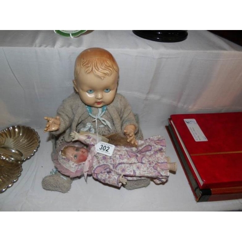 302 - A vintage doll and a small porcelain doll