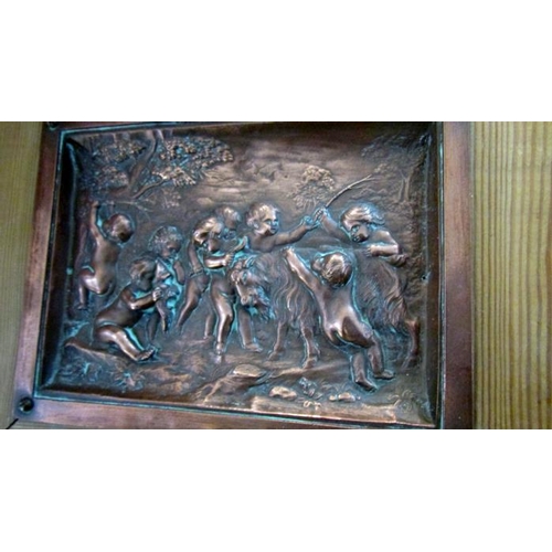 356 - A pair of copper cherub plaques in pine frames