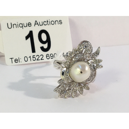 19 - A high carat white gold floral diamond ring with central pearl, size J