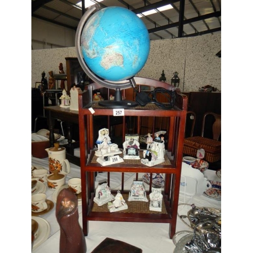 257 - A dark wood stained & wicker book shelves & an electric light up globe