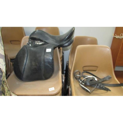 469 - A leather saddle and stirrups