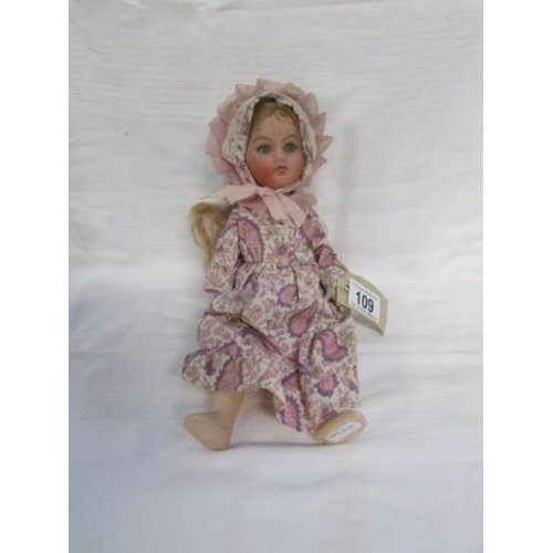 109 - A porcelain headed doll with plastic body