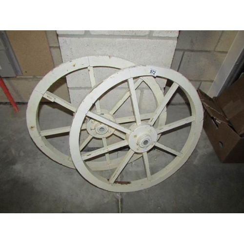 972 - A pair of wooden hand cart wheels with metal hubs, approx. 25'' diameter