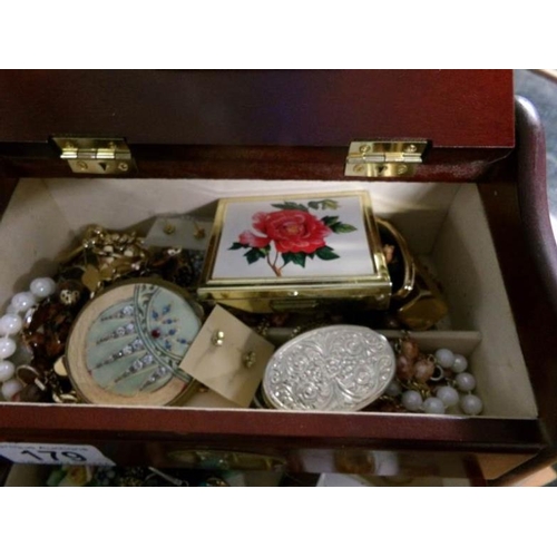 179 - A jewellery box containing costume jewellery and compacts