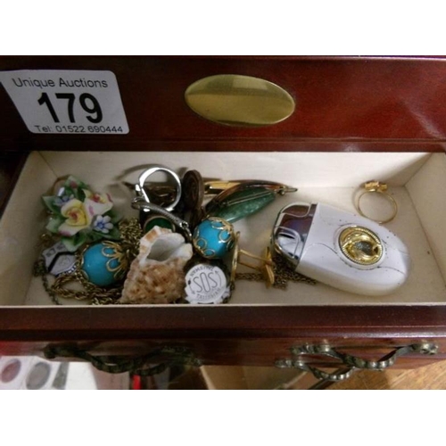 179 - A jewellery box containing costume jewellery and compacts