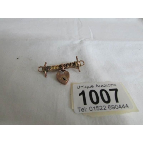 1007 - A bar brooch with gold padlock