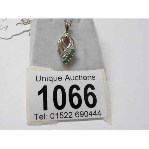 1066 - A 9ct gold diamond and emerald pendant on 9ct gold chain