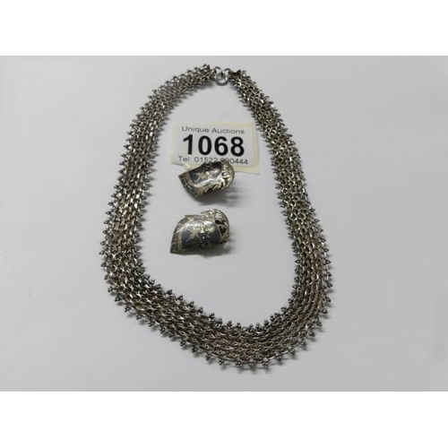 1068 - A pair of Siamese silver earrings and a white metal necklace