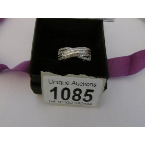 1085 - A diamond criss-cross ring in platinum overlay on sterling silver, 0.5ct, size T