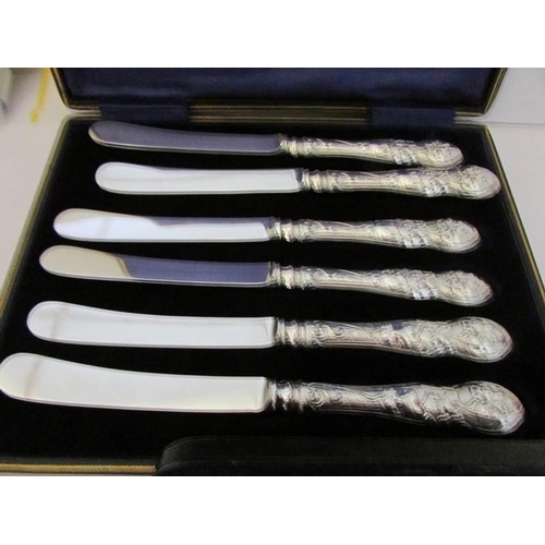 1092 - A cased set of 6 silver handled butter knives (H M Sheffield 1904-06) and a cased silver sugar nips ... 