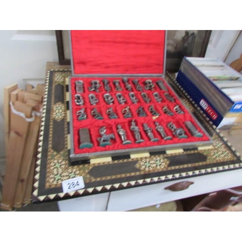 284 - A cased chess set and board