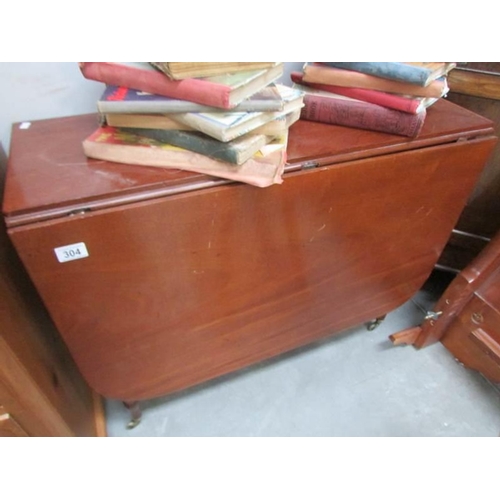 304 - A mahogany drop leaf table on brass casters