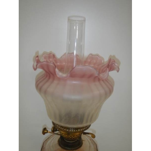 113 - A good Victorian oil lamp with cranberry tint to shade.