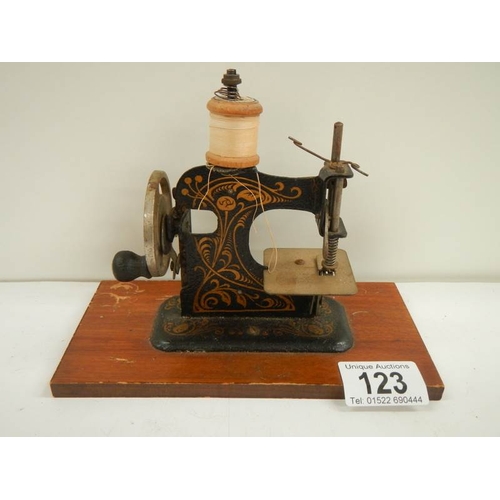 123 - A miniature hand operated sewing machine, made in Germany.