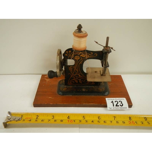 123 - A miniature hand operated sewing machine, made in Germany.