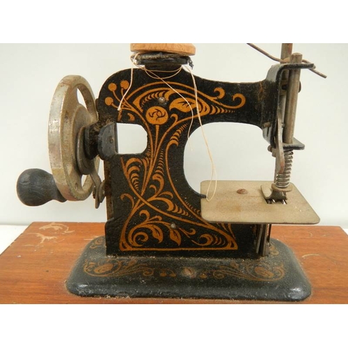 123 - A miniature hand operated sewing machine, made in Germany.