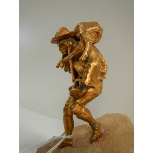 152 - A small gilded figure of a mountain goat farmer standing on a rock, 5.5'' tall.