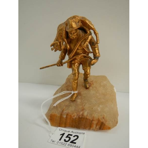 152 - A small gilded figure of a mountain goat farmer standing on a rock, 5.5'' tall.