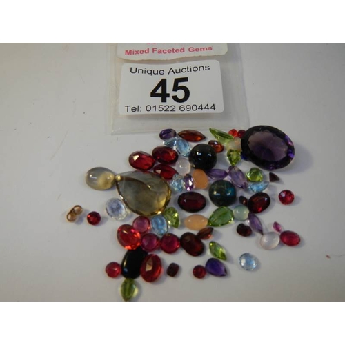 45 - A mixed lot of loose gem stones including rubies, approximately 50 in total.