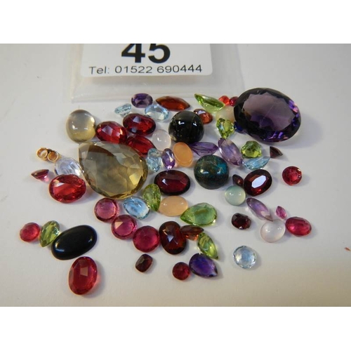 45 - A mixed lot of loose gem stones including rubies, approximately 50 in total.