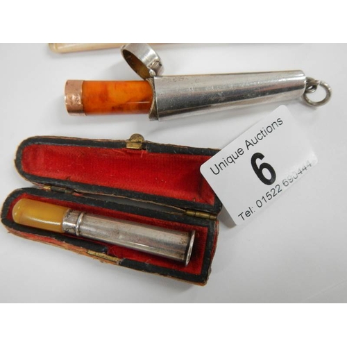 6 - A cased silver cheroot holder with 9ct gold band (a/f), an engraved bone cigarette lighter and anoth... 