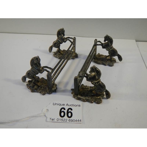 66 - An unusual pair of pewter knife rests being horses jumping fences.