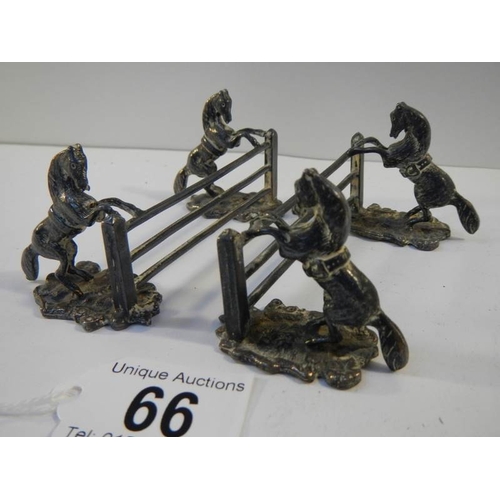 66 - An unusual pair of pewter knife rests being horses jumping fences.