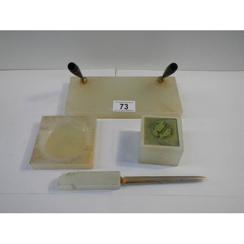 73 - A 4 piece onyx desk set including paperweight, letter opener, ashtray (slight chip) etc.,