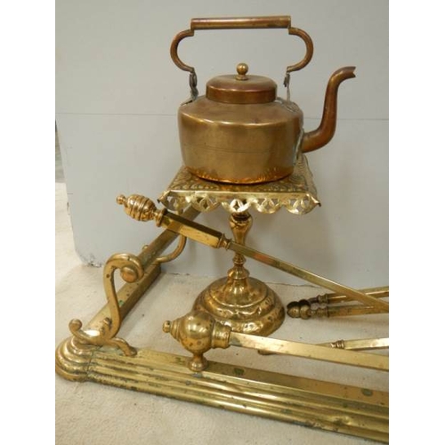 81 - A Victorian brass fender, set of brass fire irons, brass trivet and copper kettle.