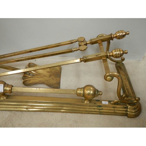 81 - A Victorian brass fender, set of brass fire irons, brass trivet and copper kettle.