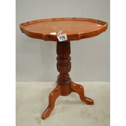 179 - A teak oval tripod table