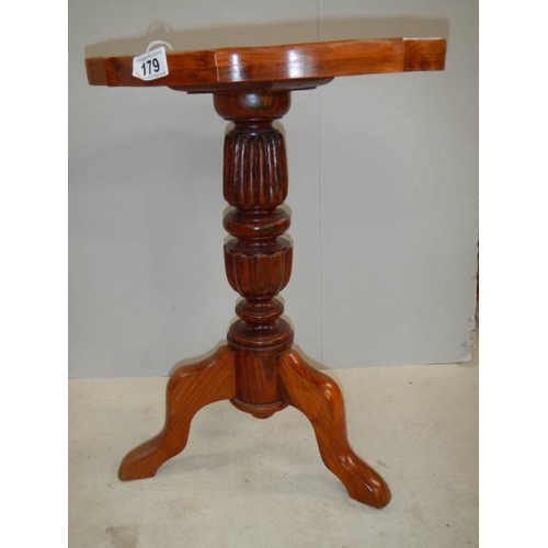 179 - A teak oval tripod table