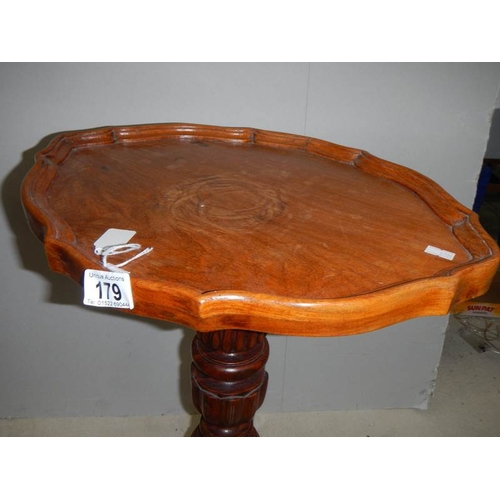 179 - A teak oval tripod table